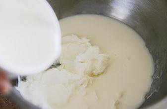 3、轻乳酪杯子蛋糕,将奶油奶酪隔热水化软后,加入淡奶油和牛奶,用手动打蛋器搅打顺滑至无颗粒。