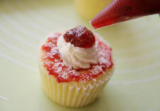 11、轻乳酪杯子蛋糕,在凹陷处挤上加了糖的打发淡奶油。撒上椰丝,再挤上少许果酱,或加浆果即可。