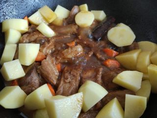 10、土豆烧排骨,将洗净去皮的土豆和胡萝卜放入，小火焖一会儿