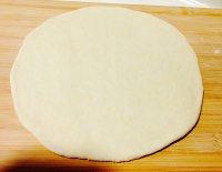 6、香蕉玉米披萨,揉成光滑面团后,面板撒薄面、擀圆面皮。