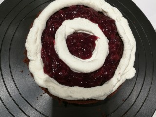 17、经典黑森林蛋糕,取出冷藏过的打发奶油，装入裱花袋中。将蛋糕片放在裱花转盘上，挤上奶油和樱桃酱，轻轻放上另一层蛋糕片，压一压，再挤上奶油和樱桃酱。