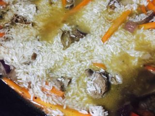 6、新疆手抓饭,加少量鲜味生抽、适量盐炒匀，加开水至没过羊肉表面，加入葡萄干。移入铸铁锅将羊排铺平，放入调料盒。上面铺上泡好的大米，加汤至没过大米表面，大火烧开后转小火焖约50分钟，打开拌匀即可。