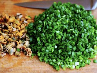 4、鲜掉眉毛的烟台韭菜盒子,在醒发面团期间，咱们来把韭菜盒子的馅料做一下吧，用刀把韭菜切成碎末，再用刀把海虹切成小块，记住海虹不要切的太碎哈，切的太碎，影响口感也影响颜值哈；