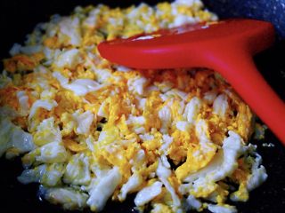 5、鲜掉眉毛的烟台韭菜盒子,陶瓷锅烧热后，加入花生油烧至6成热时，把鸡蛋直接打散在锅中，用硅胶铲子来翻炒鸡蛋，（直接打散在锅中的鸡蛋，口感爽滑细腻又鲜嫩，大家可以试试哈）