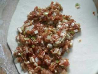 3、老北京肉饼,把面团平均分成3等分，去一块面团擀成大片，平铺猪肉大葱馅，铺平。