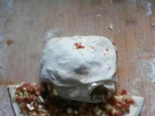 7、老北京肉饼,包裹到最后时候，稍微拉抻一下饼皮，尽量不要露出馅料来，四周的缝隙捏合紧密。