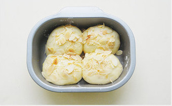 6、【杏仁豆沙面包】,表面刷上融化的黄油，撒上粗粒砂糖和杏仁片，烤箱预热180℃，中层烘烤20分钟即可，中途观察面包上色情况，考虑是否加盖锡纸。