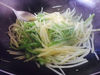 12、#圆土豆# 花椒油青椒土豆丝,放入1小勺花椒油，翻炒均匀出锅。