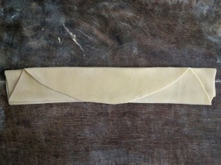 10、手擀面,把面皮层叠起来，为避免粘在一起，要在面皮间都撒上一层薄面。