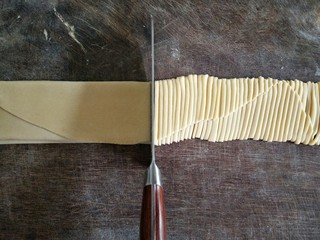 11、手擀面,用完全干燥的利刀，采用直切法缓慢而均匀地切下，宽细随意。如果面皮擀得较薄，切成宽面更好。