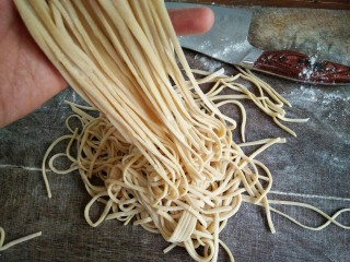 13、手擀面,把面条提起抖掉多余的薄面。