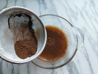 4、#做妈妈的拿手菜#可可颗粒蛋仔,将可可粉过细筛，筛入蛋液中。