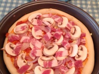 3、培根披萨,蘑菇培根片如图均匀摆好，烤箱预热200度上下火烤10分钟后