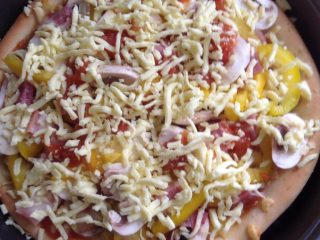 5、培根披萨,如图最后再铺满马苏里奶酪丝，放入200度上下火烤十分钟