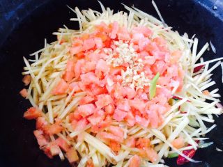 13、西红柿炒土豆,接着放入西红柿丁，姜沫，盖锅盖炒一会