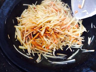 14、西红柿炒土豆,接着倒入酱油，盐，味精调味，翻炒均匀