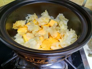 7、 银耳南瓜汤,把银耳撕成小块和南瓜一起放在砂锅里。