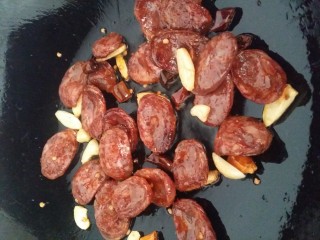 7、家常菜～笋干炒腊肠,起油锅，放红椒煸炒出味，捞出不要。(哈哈小家伙的惯用吃法)，中火放干辣椒，蒜皮翻炒一下出味，再放腊肠翻炒一下，腊肠会出油哟！(笋干就喜欢油多一些????)