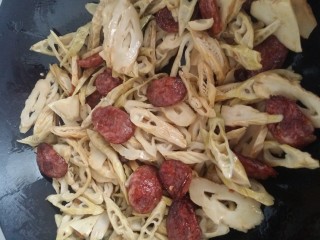 8、家常菜～笋干炒腊肠,接着倒入笋干翻炒一下，加料酒，生抽继续翻炒。