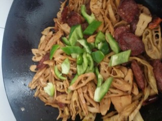 9、家常菜～笋干炒腊肠,最后加青椒，盐(适量)，鸡精翻炒一下，看着青椒断生即可盛盘。