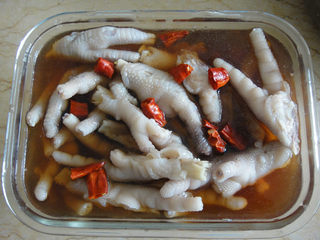 7、糟鸡爪,放入保鲜盒里倒入糟卤，糟卤能浸没食物为佳喜欢有点辣味，用三个干辣椒洗净后剪开加入盖上进冰箱冷藏4小时以上即可食用