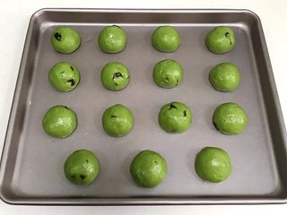 10、抹茶蔓越莓麻薯,带上一次性手套，将抹茶麻薯面团分成15等份，搓圆放入烤盘中，盖好保鲜膜静置20分钟。