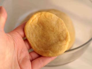 7、大黄米年糕,取一小团面团，用手摊薄，尽量边缘薄一些，中间稍厚一点；