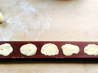 6、巧果#有个故事#,模具里撒满面粉、转匀再倒出多余面粉、把切好的小剂子放到模具里、按压结实