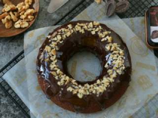 11、布朗尼蛋糕,用勺子把甘纳许淋在蛋糕体上，撒核桃碎装饰即可。