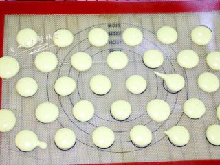 5、蛋黄溶豆,蛋黄糊装入裱花袋，裱花袋口先不要剪，没有裱花袋用保鲜袋一样的。差不多一样大挤在烤垫上。