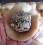 13、京式提浆五仁月饼,取一份饼皮，拍成小圆饼，包入一份馅