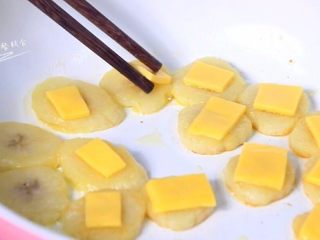 5、奶酪香蕉片,一面煎黄，翻面，奶酪丁摆在香蕉片上。