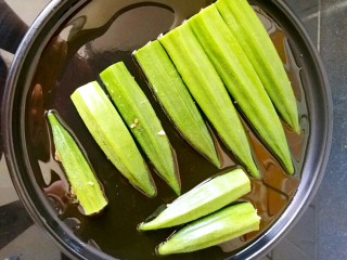 8、煎酿秋葵,烤盘刷油（因为用铁锅加工秋葵会变色，影响成品的卖相，所以我选用的是陶煲王的陶瓷烤盘），然后把填充了肉馅儿的那面朝下，将秋葵依次摆放好，中火煎制。