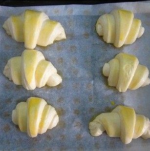 11、可颂,发酵至二倍大小后取出,表面刷蛋液(小心不要刷到旁边,避免沾到层次,蛋液只刷正面),入烤箱200度热,放中层,上下火,烤15分钟即可。