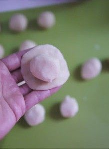 4、黑芝麻酥皮月饼,取一只油皮，用手掌按扁，注意中间略厚四周薄包入一只油酥，包好后收口向下，按扁。