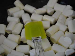 5、花生牛轧糖,用刮刀轻轻翻拌，手法是快速的边翻边压。