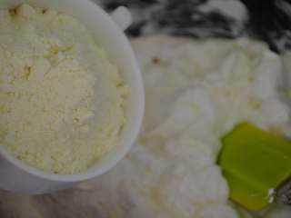 7、花生牛轧糖,棉花糖完全融化后，迅速倒入奶粉。