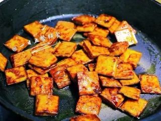 7、蜜汁豆干,让豆腐干入味。当汤汁变少时不停翻炒大火收汁，汤汁都收干了关火。