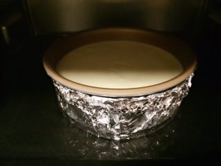 14、轻乳酪蛋糕,把蛋糕糊倒入模具，双手握住模具两边轻轻上下磕几下，蛋糕液里的大气泡会升上来破掉，这样做出的蛋糕会更细腻。把烤盘加1.5厘米的水，190度上下火预热5分钟。放进模具，调整成170度烤制80-90分钟。这种方法叫水浴法。