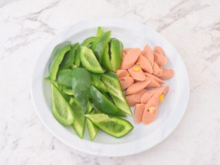 2、青椒火腿肠炒鸡蛋,火腿肠去除外包装切片,青椒去籽洗净切成小块