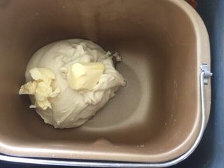 7、佛系养生黑芝麻辫子面包,第七步:加入软化的黄油再次启动揉面程序