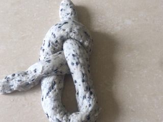 18、佛系养生黑芝麻辫子面包,第十八步:然后从底部塞进洞中拉出来