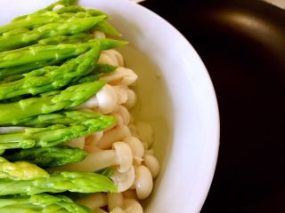 15、绿色美食+葱油芦笋白玉菇,将渗出的汤汁倒入锅内（用一只手轻轻压着芦笋，尽量滗干水份）小心不要连菜全部倒入锅内了