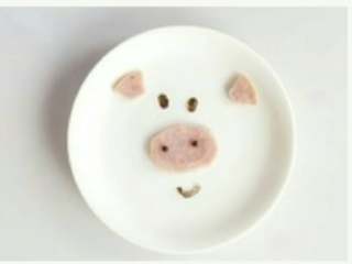 4、儿童餐 小猪蒸蛋,按图将火腿切成扇形、椭圆形，海苔剪成两大两小的圆形和一个弯弯条。然后将整理好的火腿片和海苔摆成小猪的形状，放在鸡蛋羹上面即可