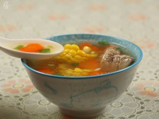 15、胡萝卜玉米排骨汤,把汤盛入碗里，撒上少许的葱花，即可食用。
