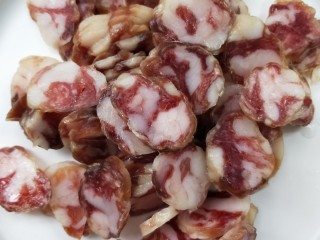 2、酱香土豆炒腊肠,温水洗净，切薄片，备用。