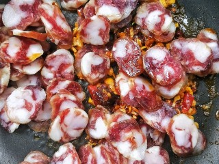 10、酱香土豆炒腊肠,倒入腊肠。
