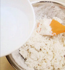 2、手撕芝麻葱油饼,接着倒入冷水搅拌，混合成团