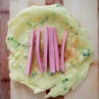 5、鸡蛋饼,火腿肠切丝，铺在饼上，卷起