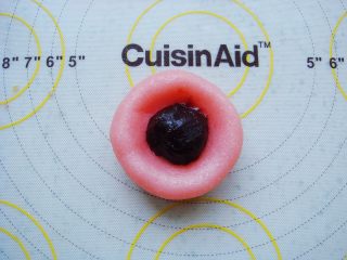 6、樱花和果子,按凹下去的小坑，放入豆沙馅，用虎口慢慢上推包起来。